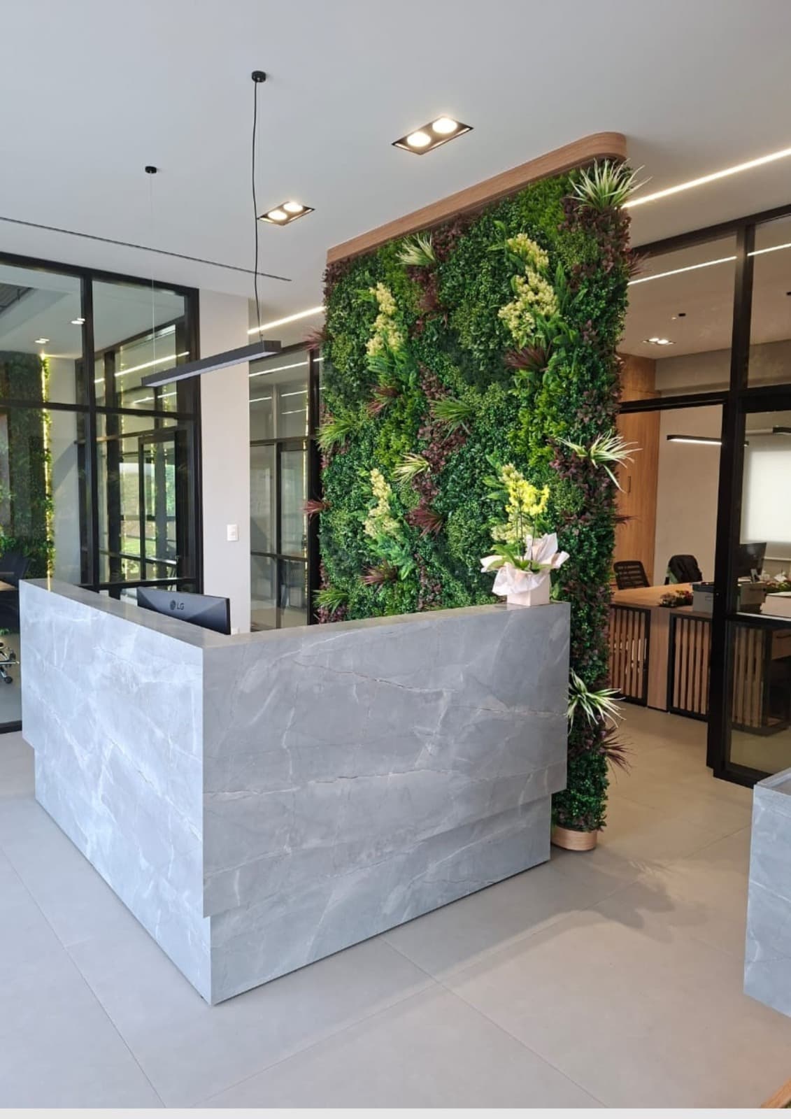 Escritório com jardim vertical artificial na parede